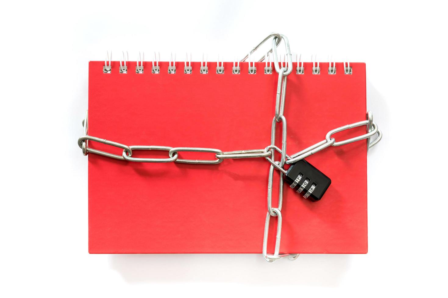 Red notebook chained with combination lock on white background photo