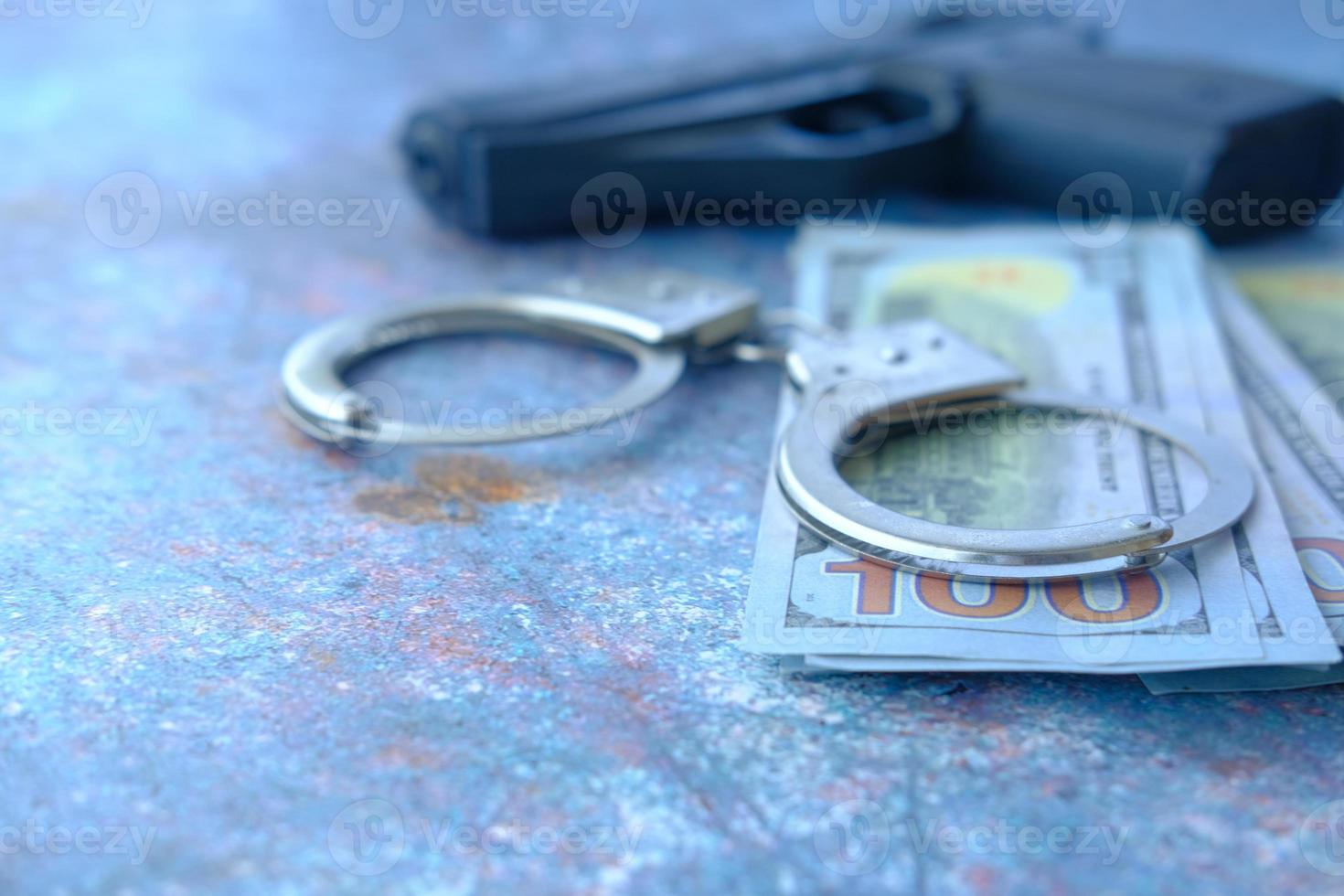 Close-up de esposas, dinero en efectivo y pistola sobre fondo neutro foto
