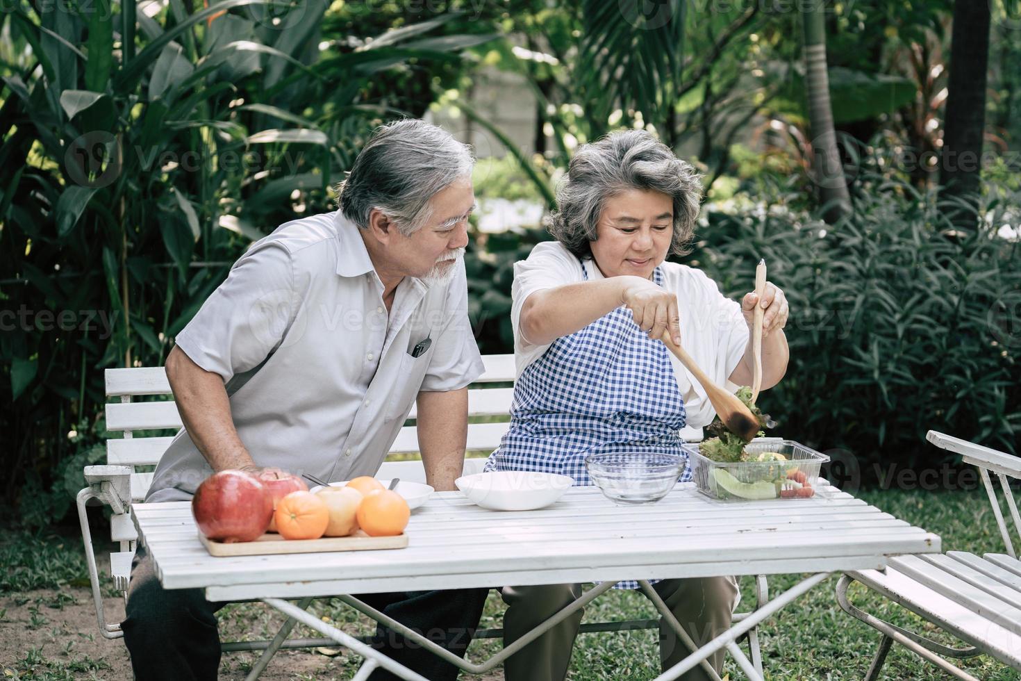 Elderly couple cooking healthy food together photo