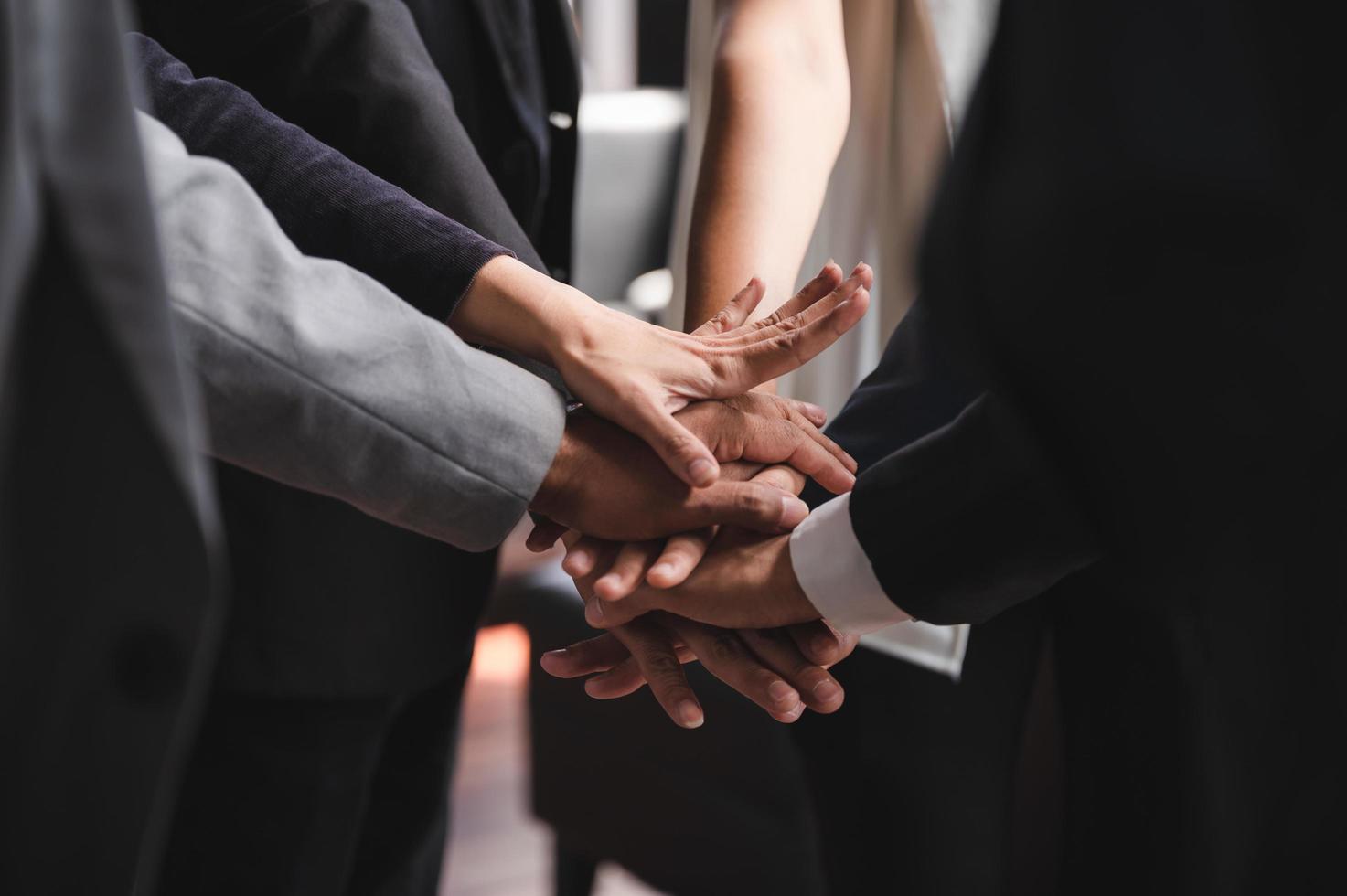 Close-up of business people stacking hands photo