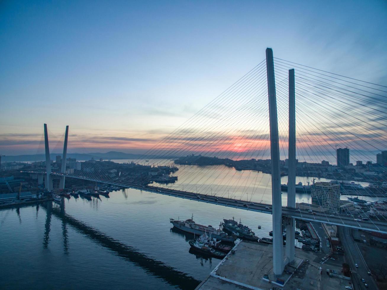 Puente Zolotoy y agua contra el cielo nublado del atardecer en Vladivostok, Rusia foto