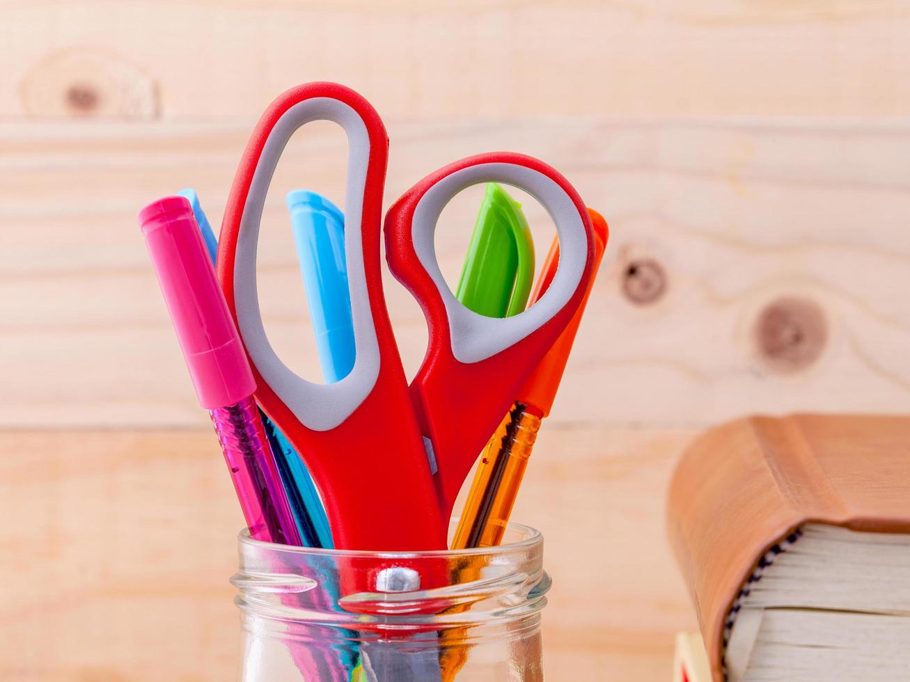Close-up of scissors and pens in a cup photo