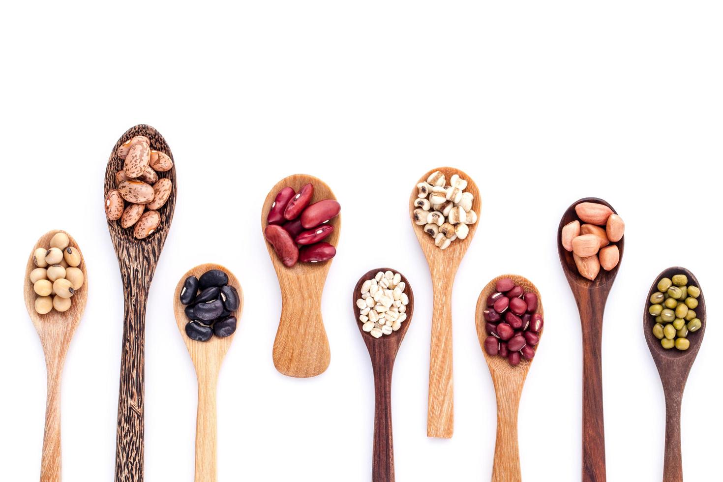 Assortment of beans and lentils in wooden spoons photo
