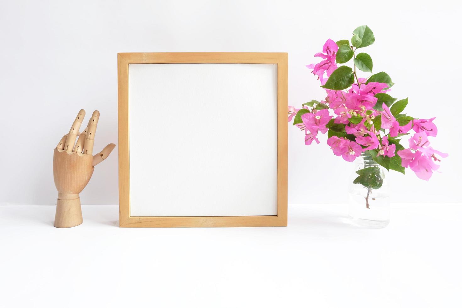 Blank wooden frame with flowers in a vase photo