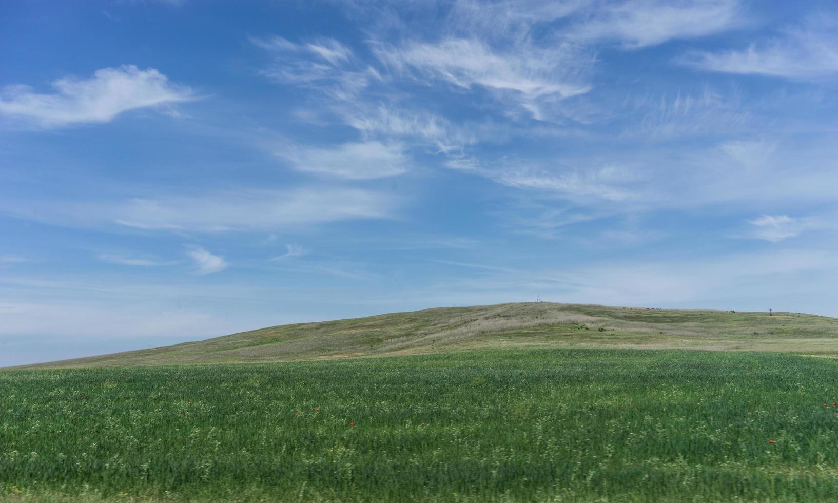 Landscape with fields and hills and cloudy blue sky photo