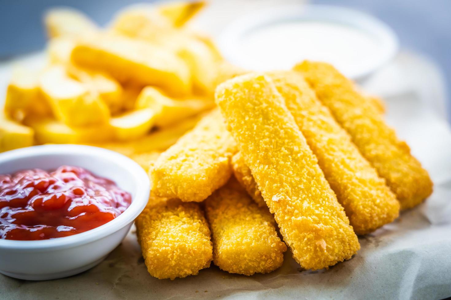 dedo de pescado y patatas fritas con salsa de tomate y salsa de mayonesa foto