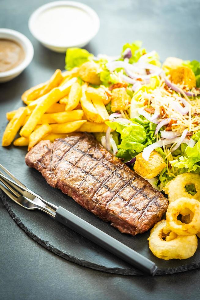 Grilled beef steak with french fries and fresh vegetables photo