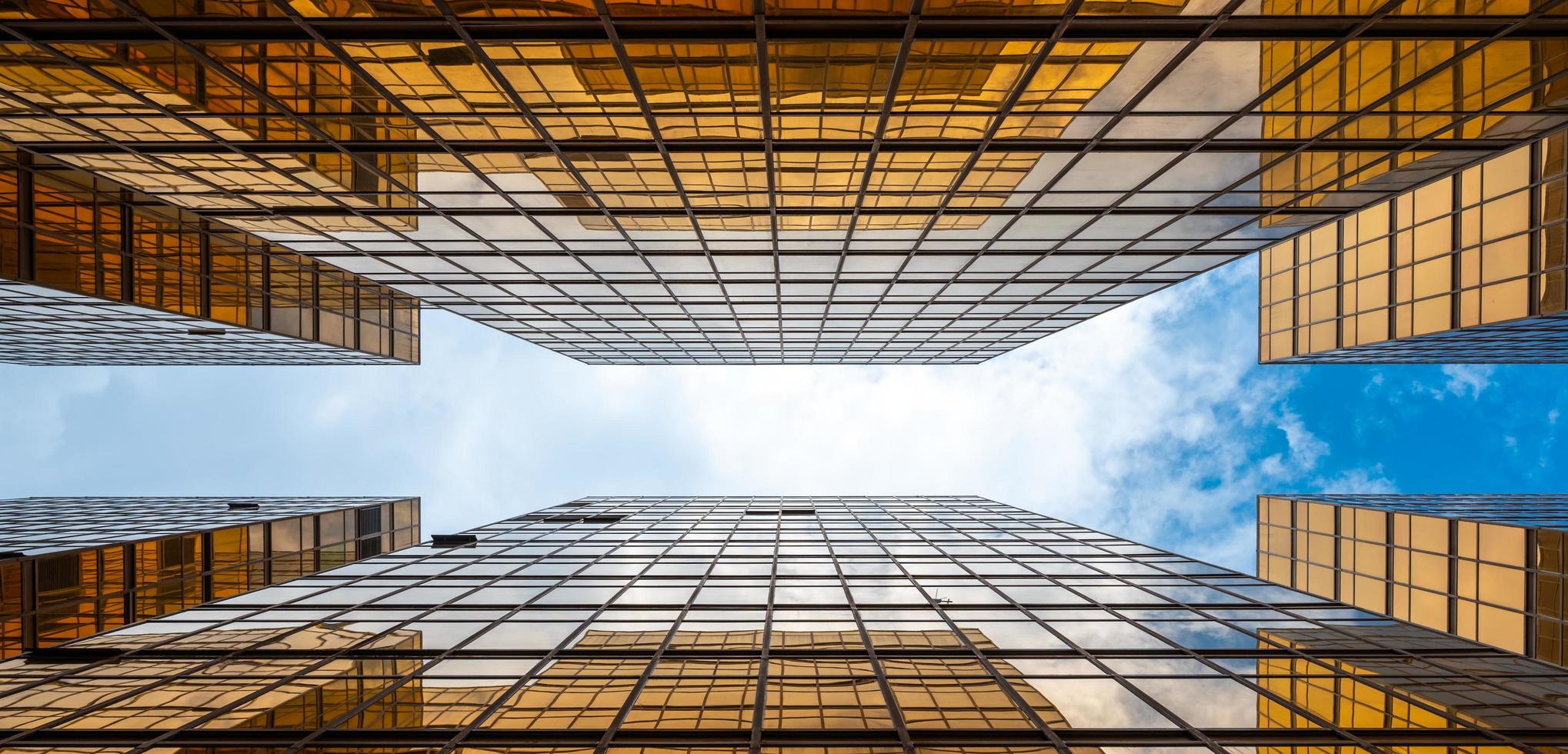 View looking up at skyscrapers with cloudy blue sky photo