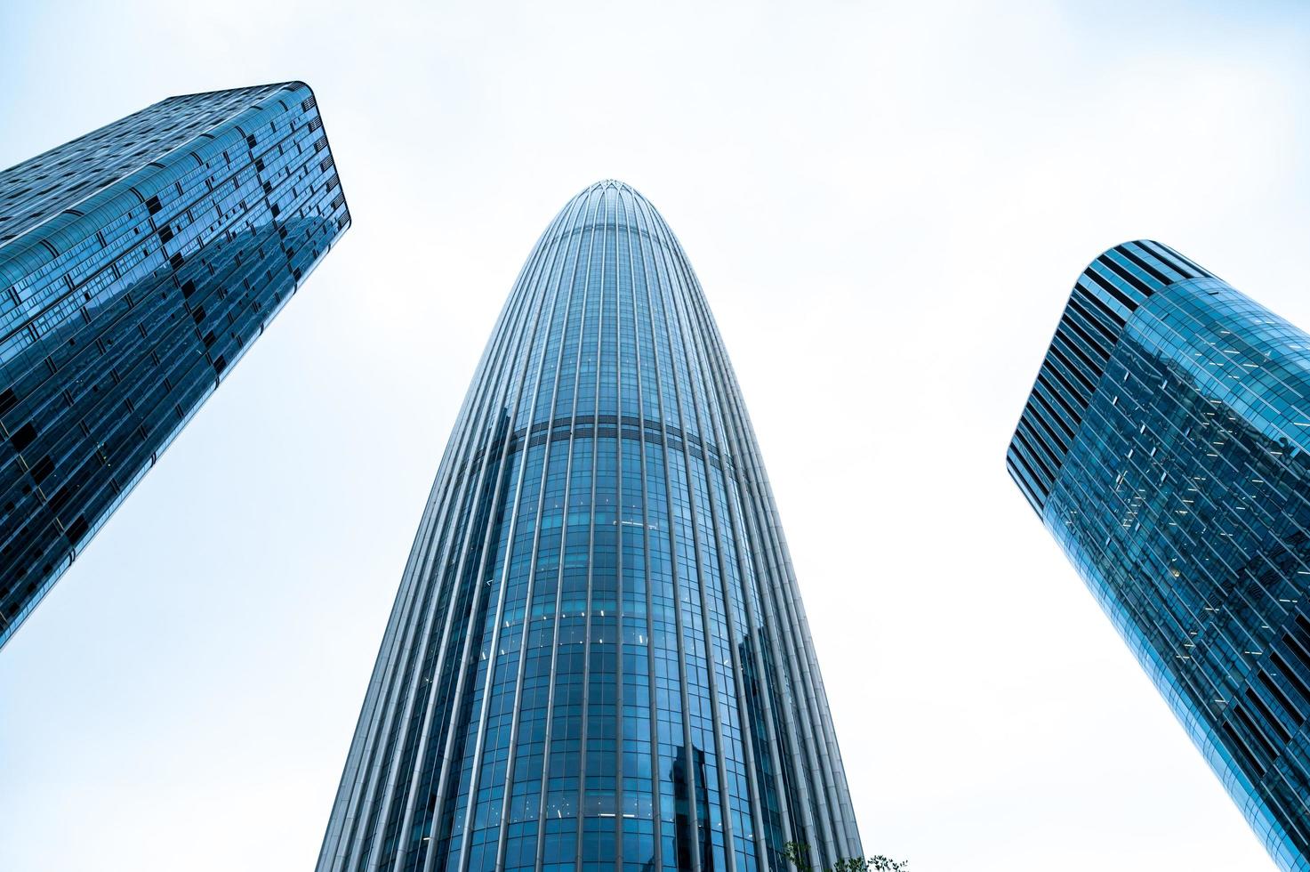 View looking up at skyscrapers with white sky photo