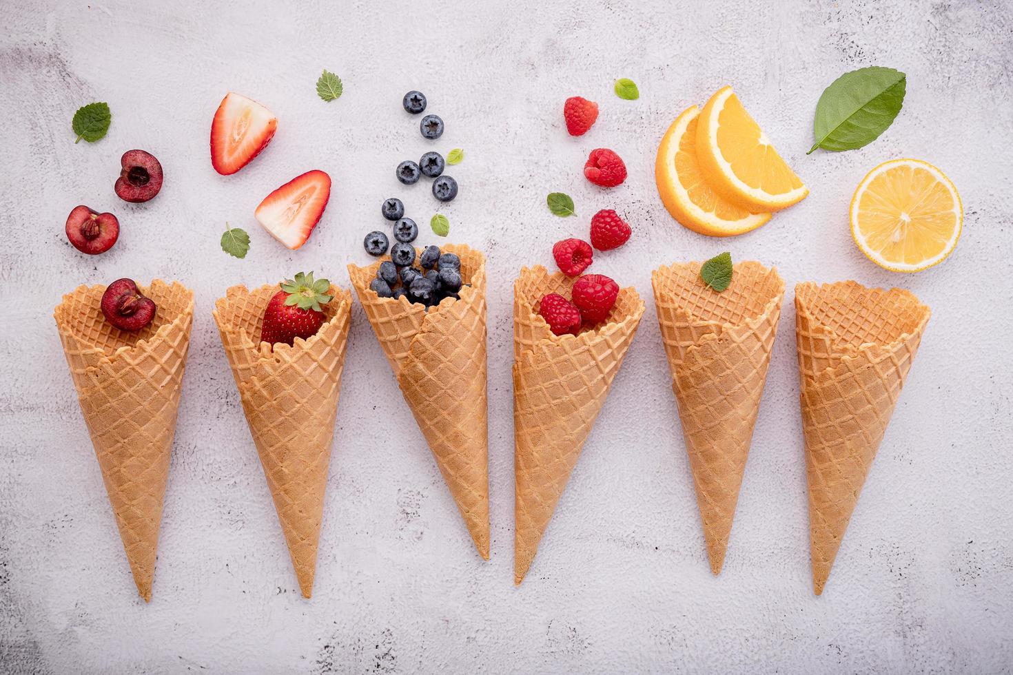 Conos de fruta y helado sobre un fondo gris claro foto
