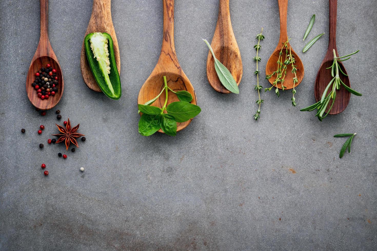 Herbs and spices in spoons on a gray background photo