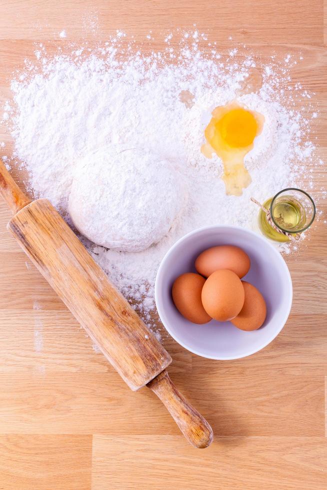 Baking ingredients and a rolling pin on wooden table photo