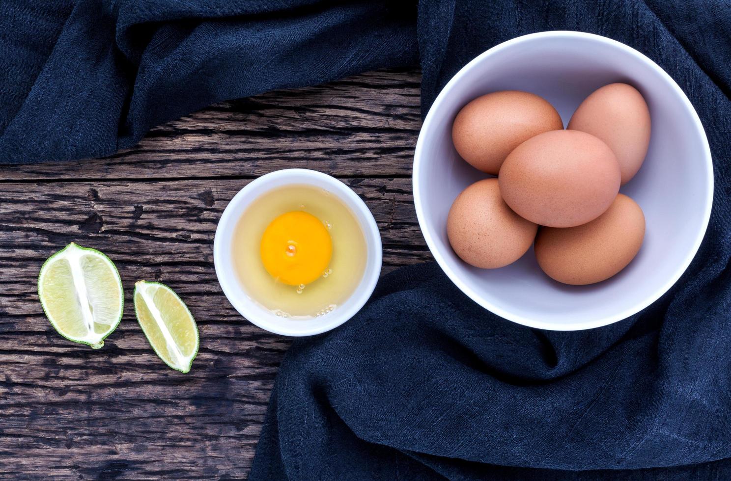 huevos frescos en un recipiente sobre la mesa de madera vieja. foto