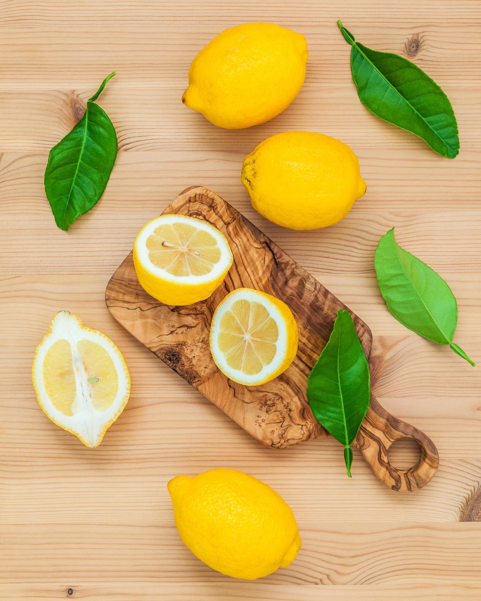 Limones y hojas de limón sobre fondo de madera rústica foto