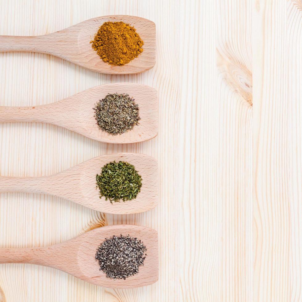 Dried spices in wooden spoons photo