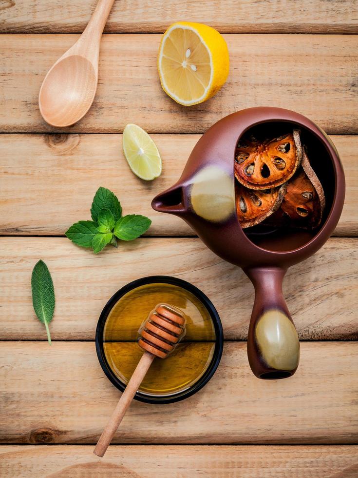 Herbal tea pot with fresh herbs on wood photo