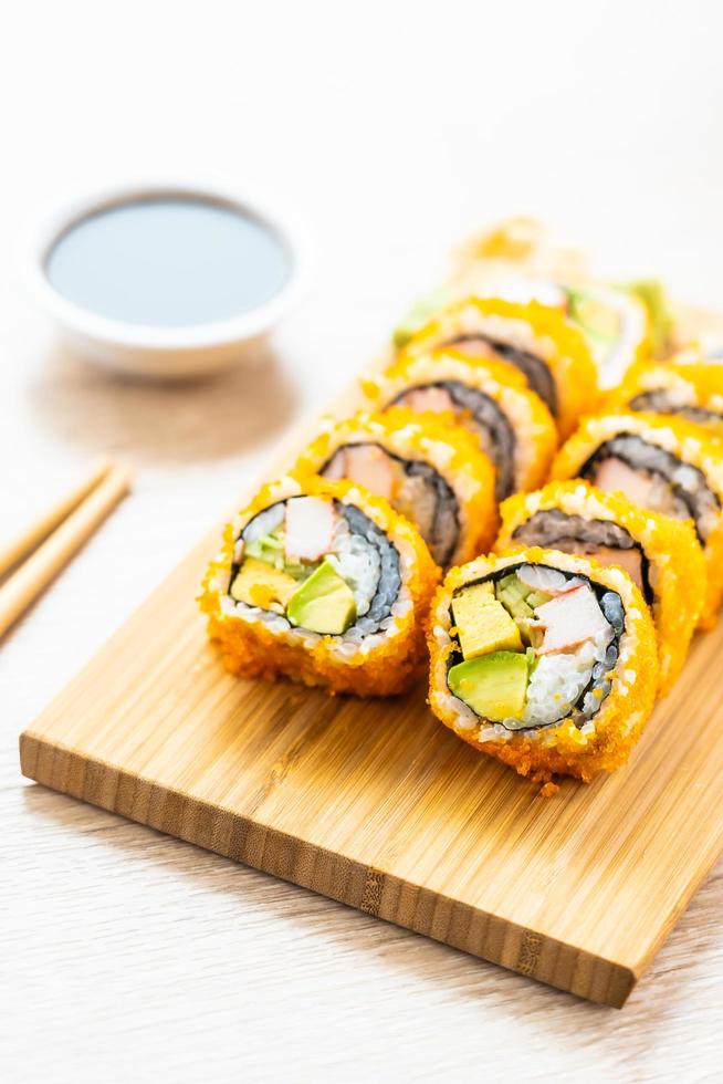 California maki rolls sushi con salsa y palillos foto