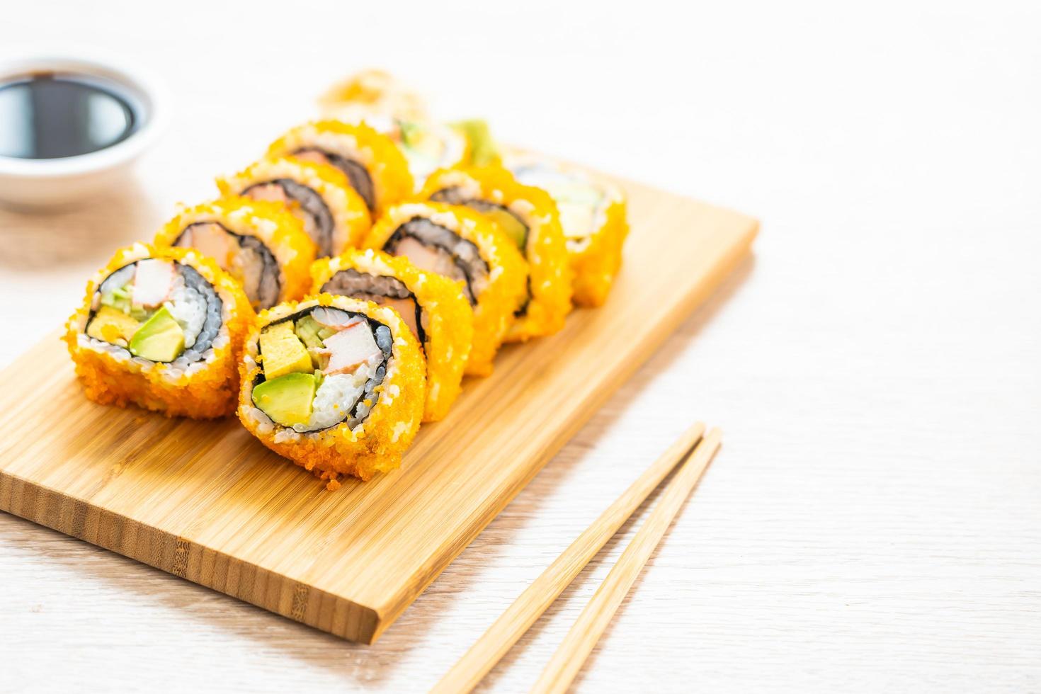 California maki rolls sushi con salsa y palillos foto