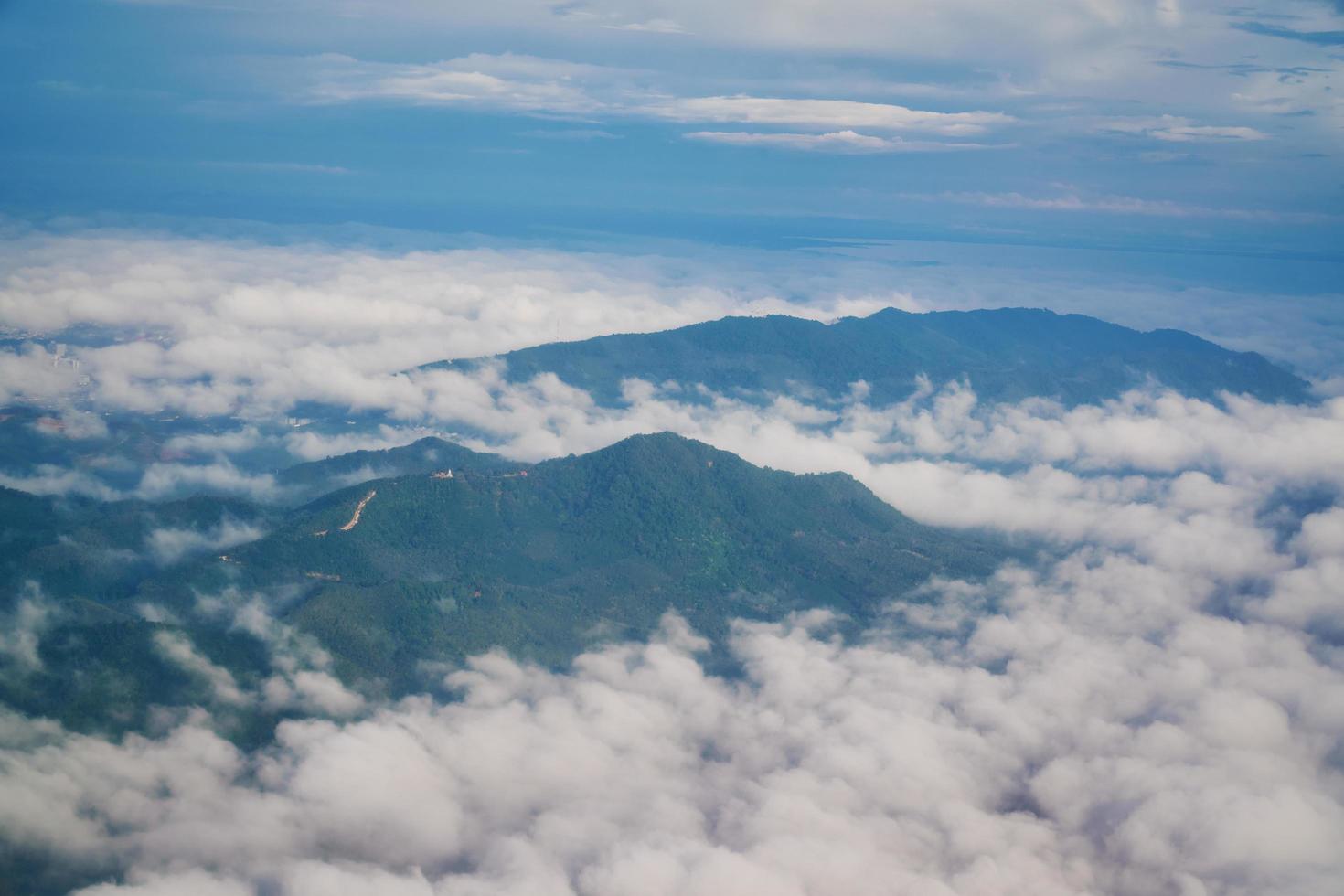 Aerial view of mountains and hills in clouds from airplane photo
