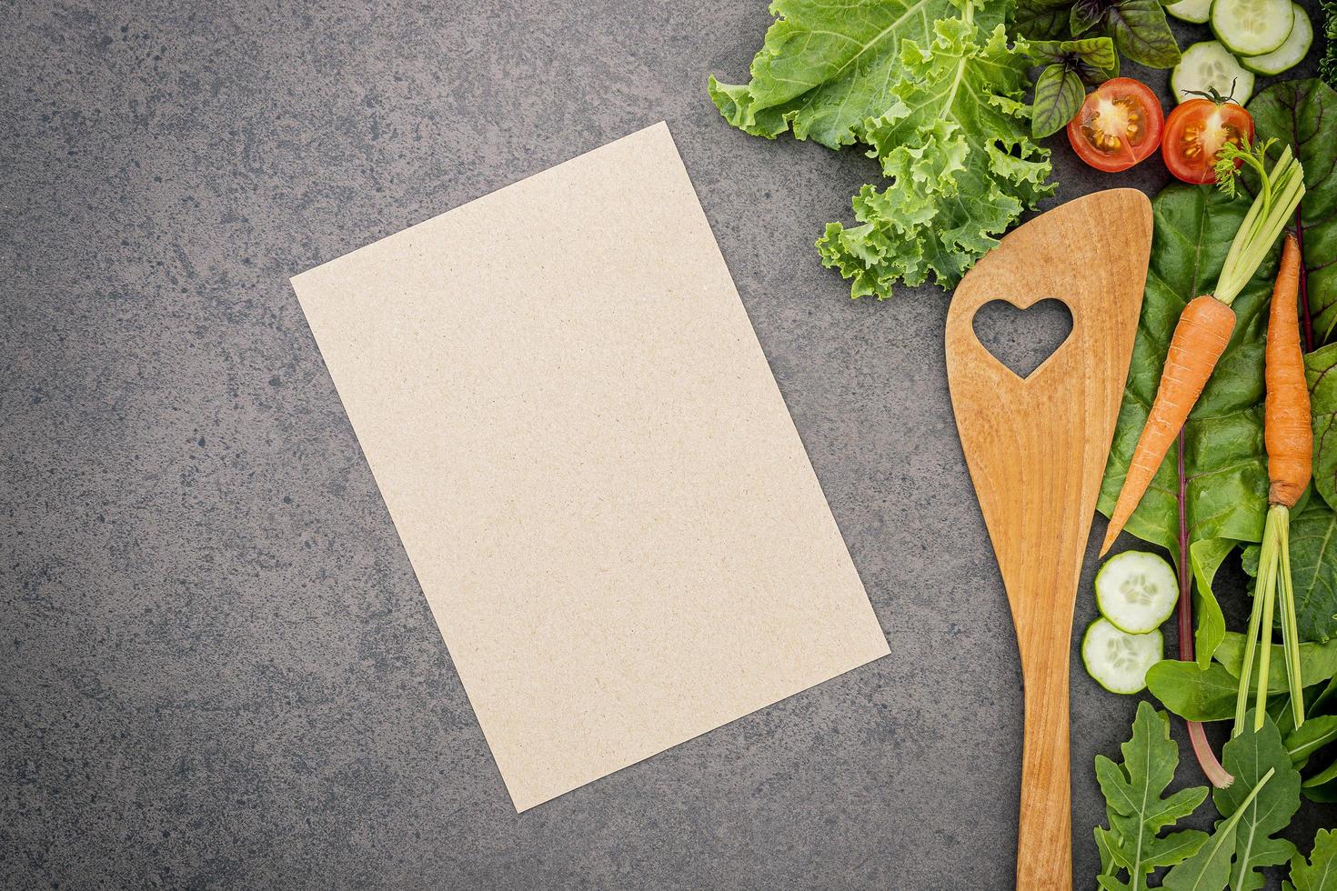 Menu mock-up with fresh salad and wooden spoon photo