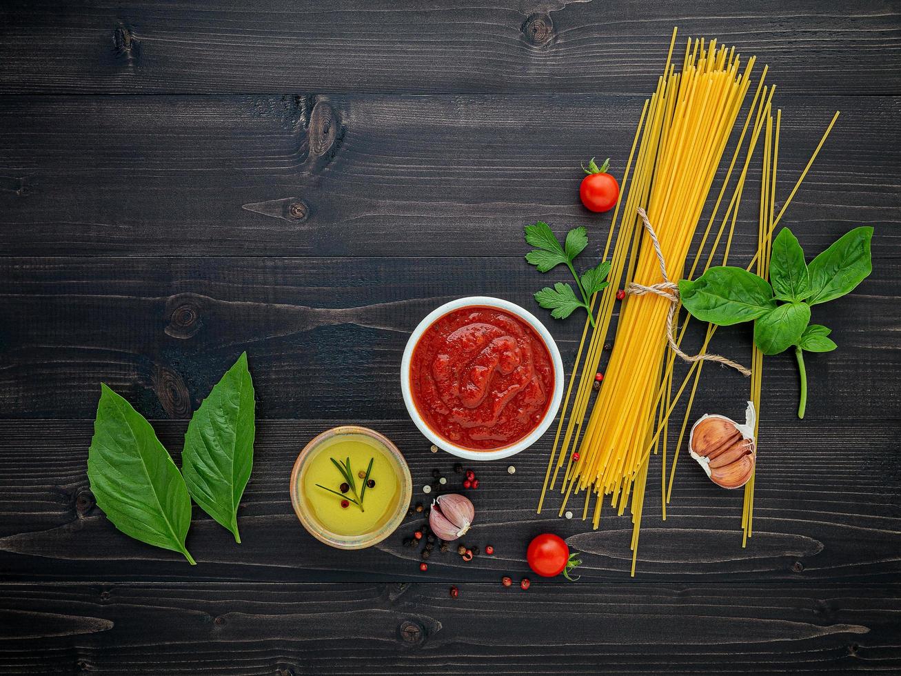 Spaghetti ingredients on dark wooden background photo