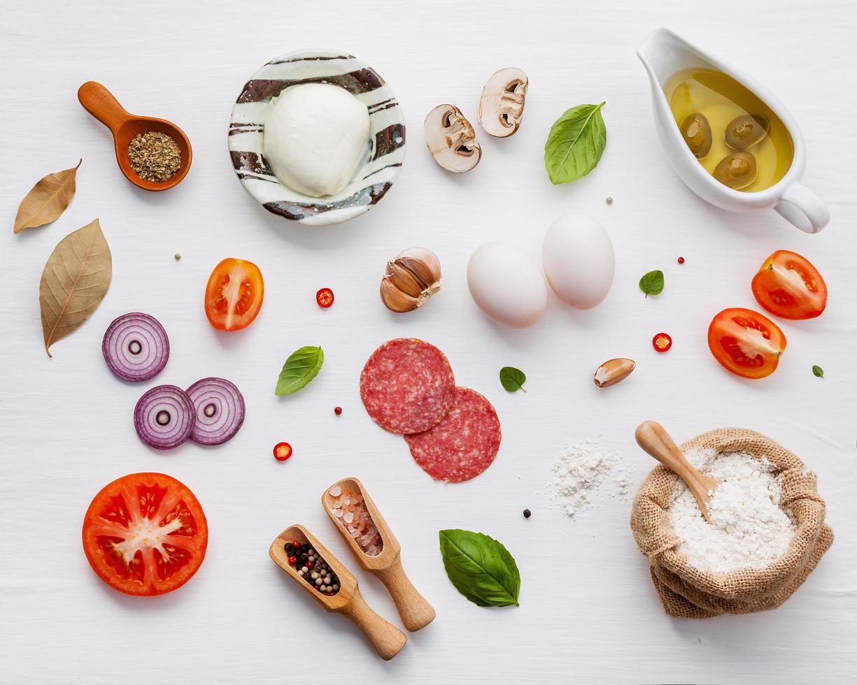 Ingredientes para pizza sobre fondo de madera blanca en mal estado foto