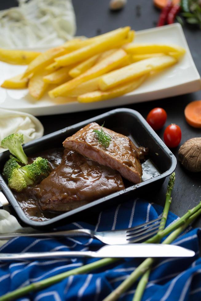 Bistec a la parrilla y brócoli en una sartén con papas fritas foto