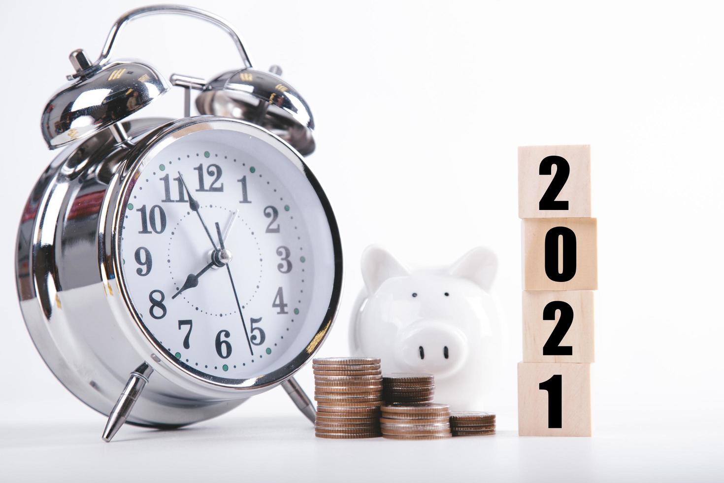 2021 New year saving money piggy bank with Wood word 2021. Money-saving concept photo