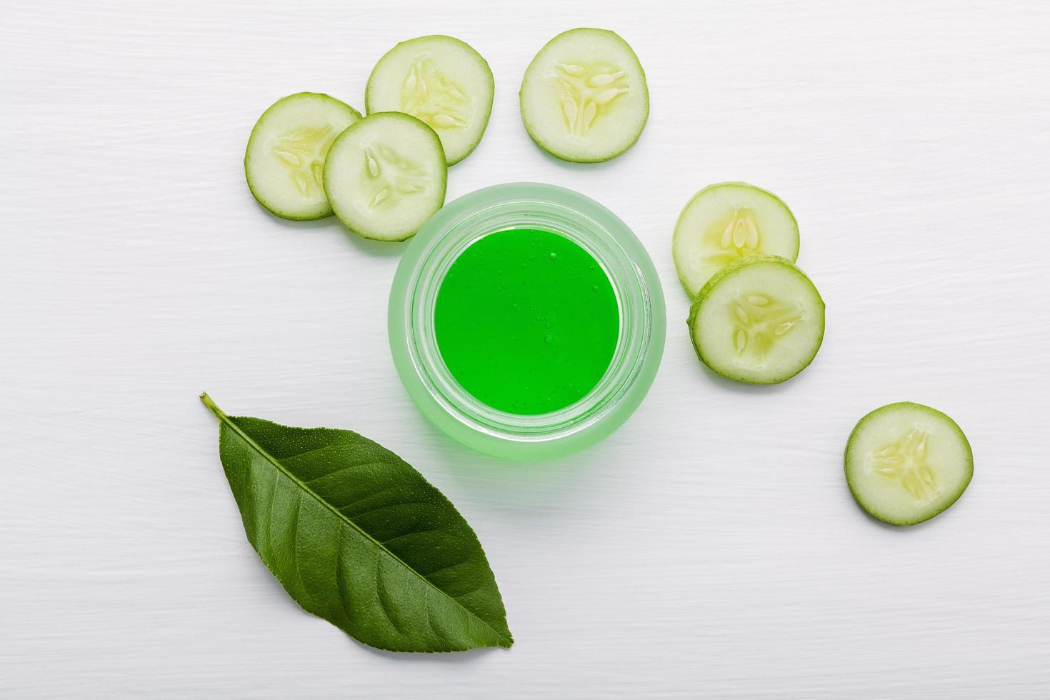 Rodajas de pepino y gel de aloe vera sobre blanco foto