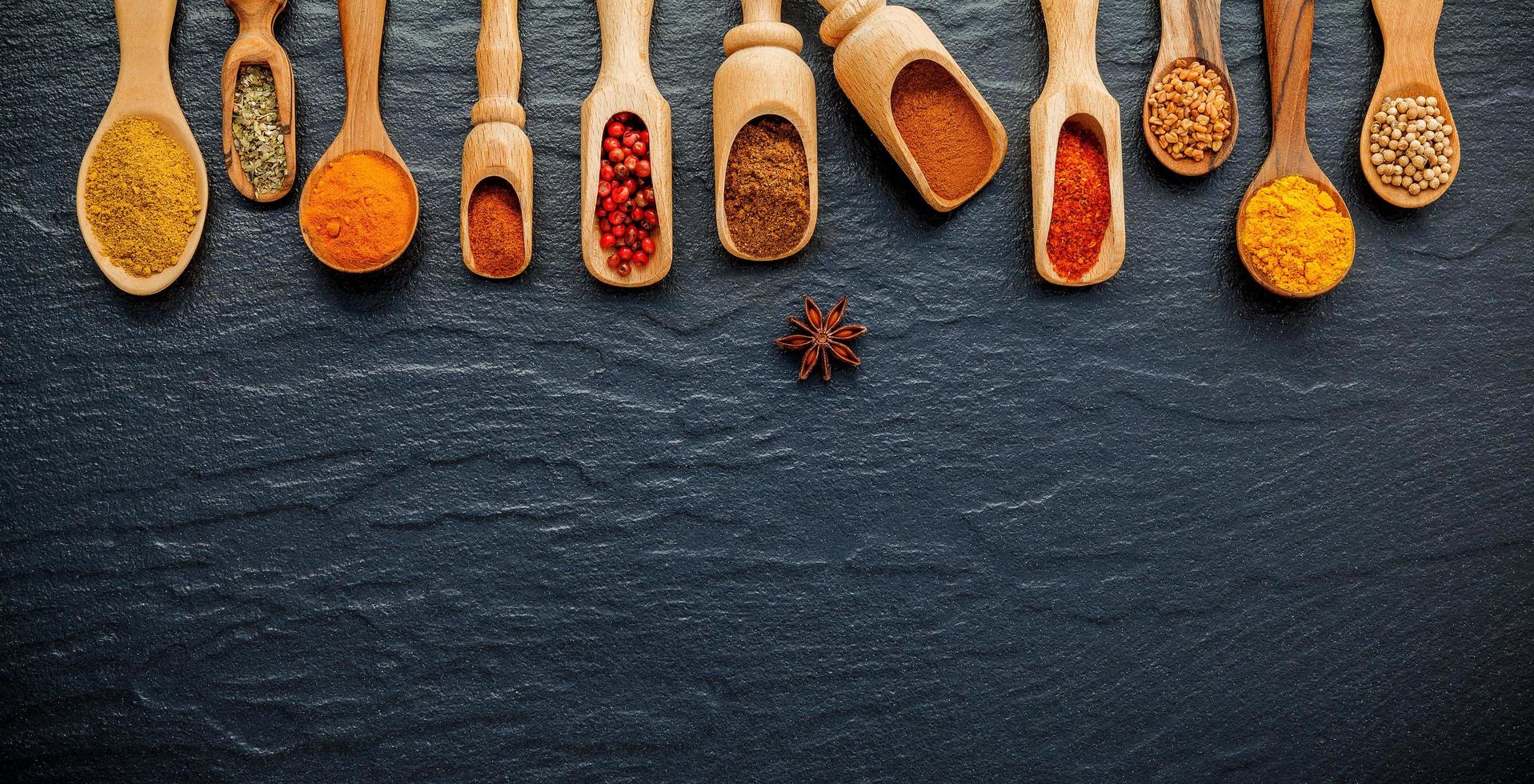 Various spices and herbs in wooden scoops photo