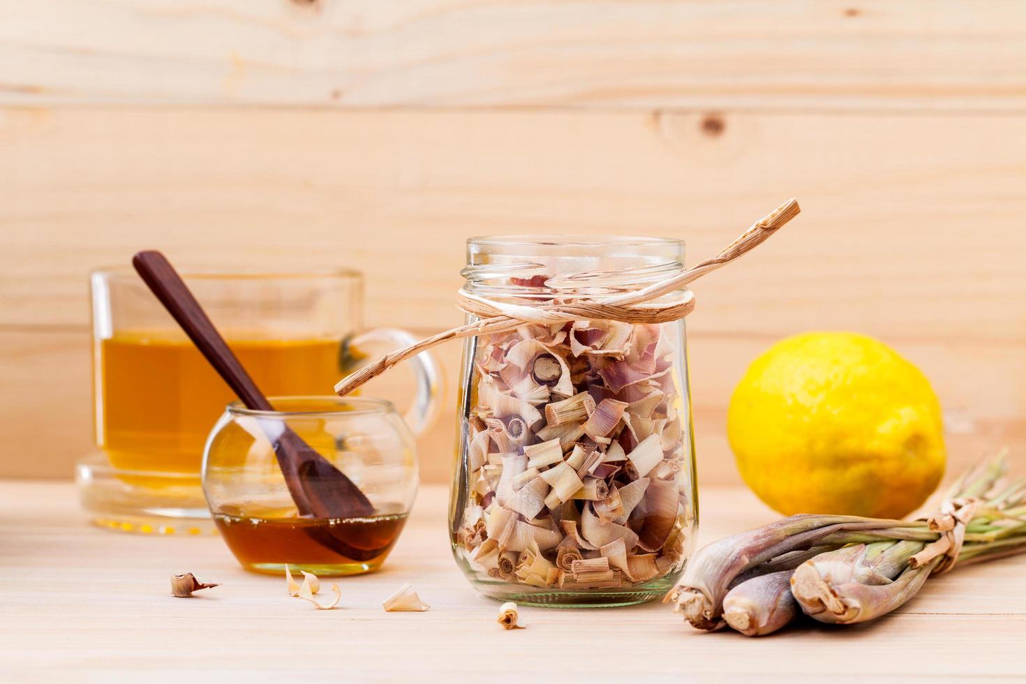 Cup of herbal tea with dried lemongrass, honey, and lemon photo