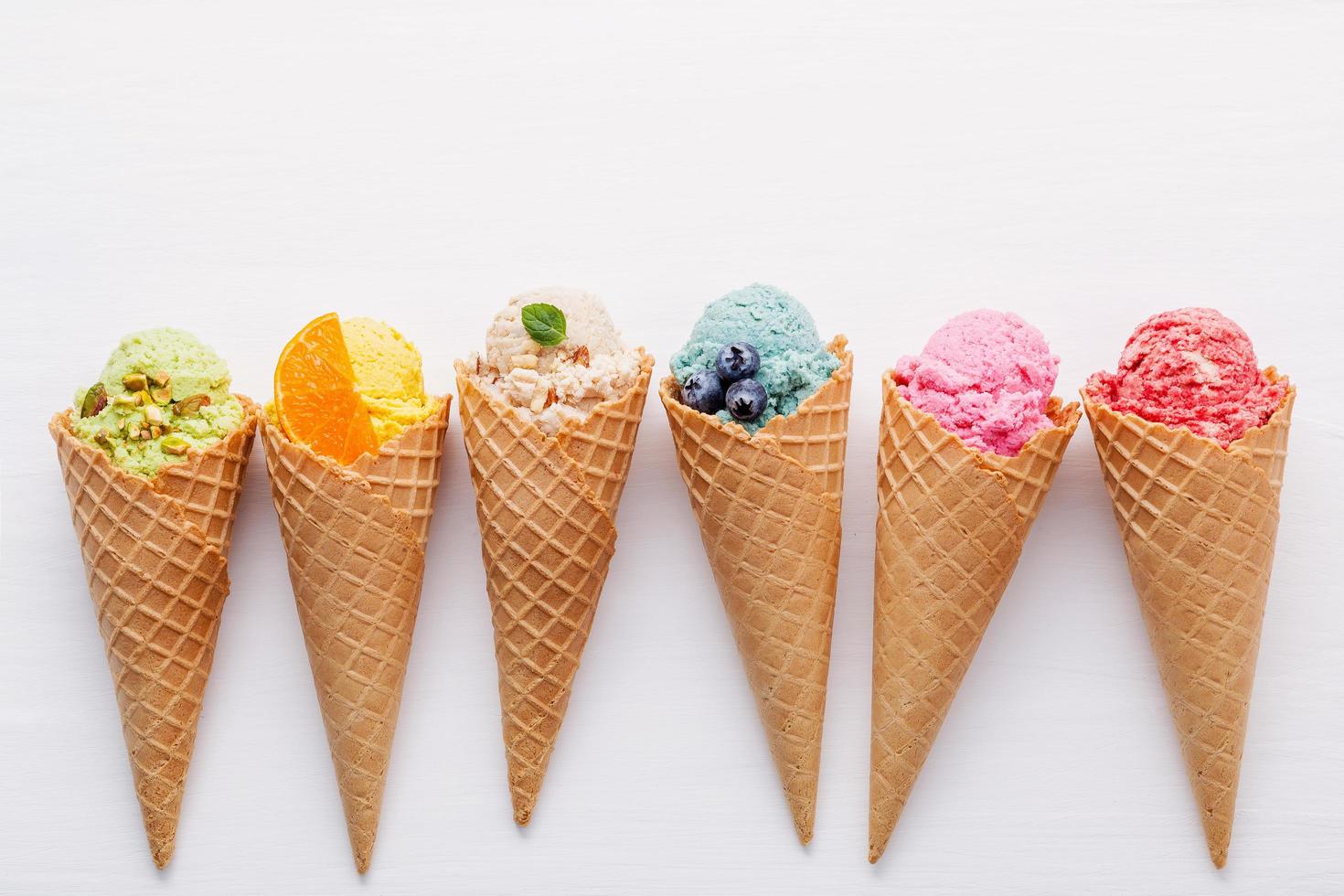 Colorful ice cream in cones on white photo