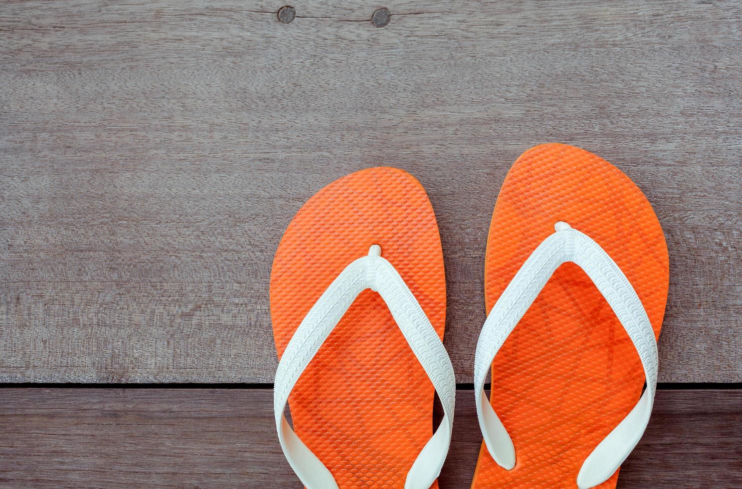 Orange flip flops on wood photo