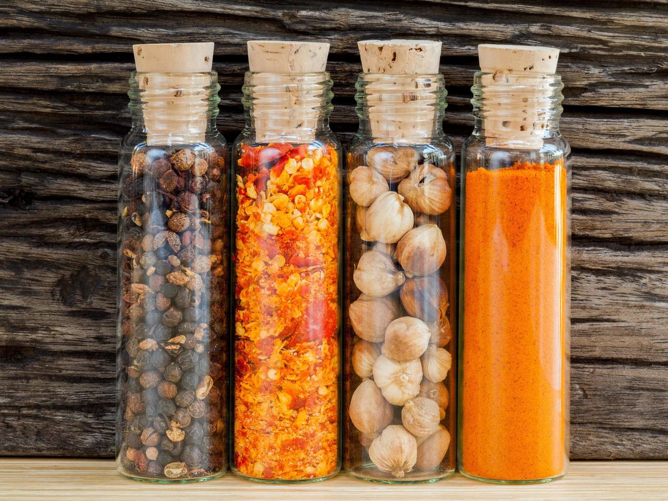 Bottles of spices against a rustic wood background photo