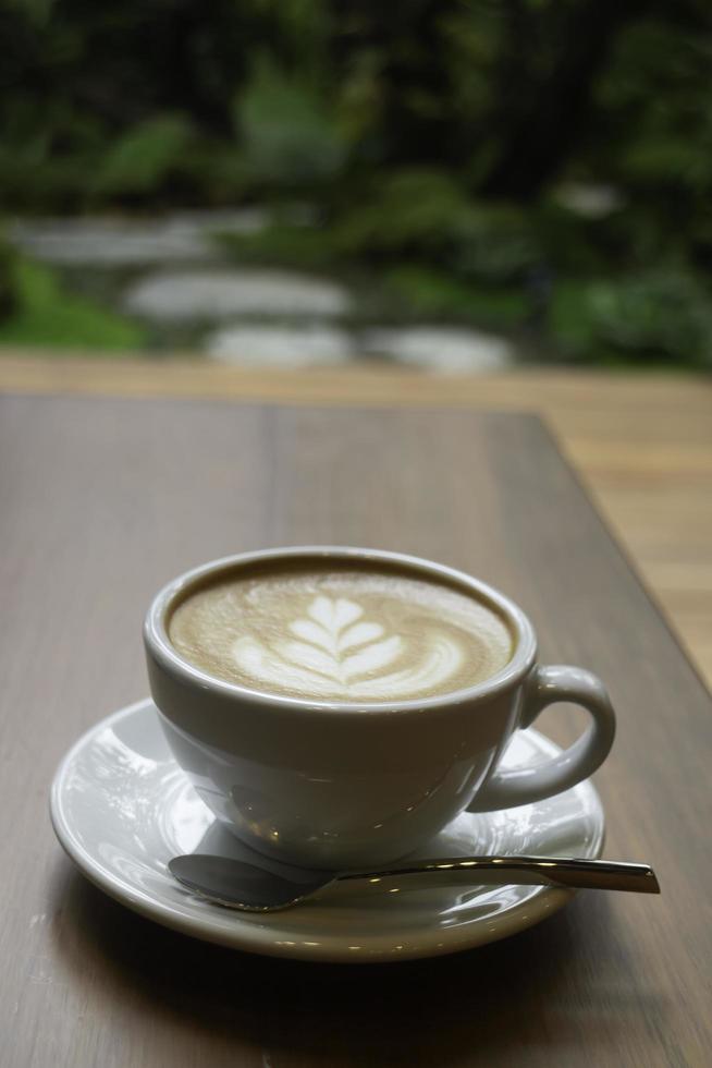 Hot latte in a mug on wooden table photo