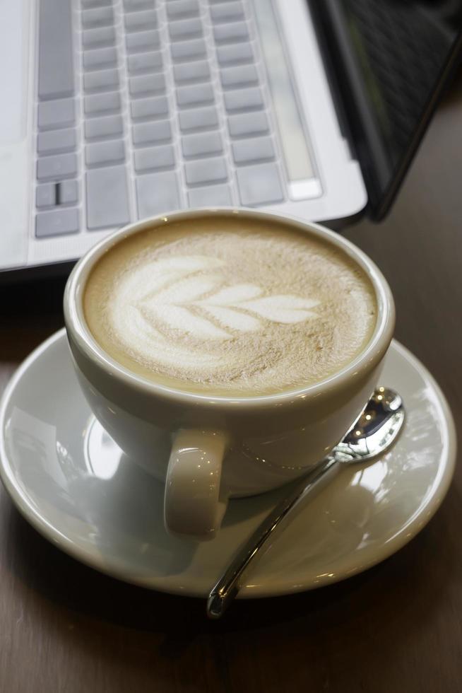 taza de café y laptop en la mesa foto