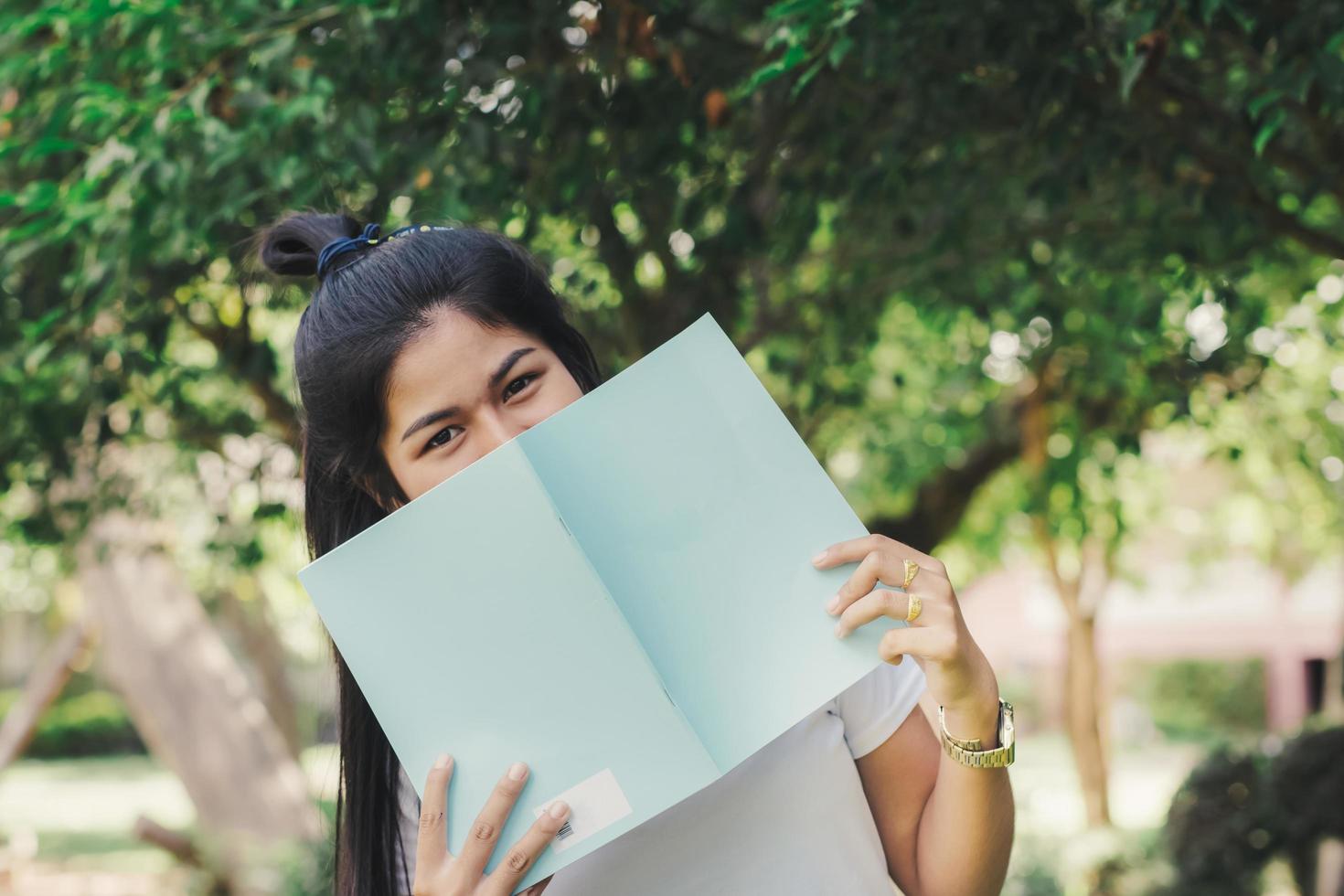 mujer sentada y leyendo un libro en el jardín foto