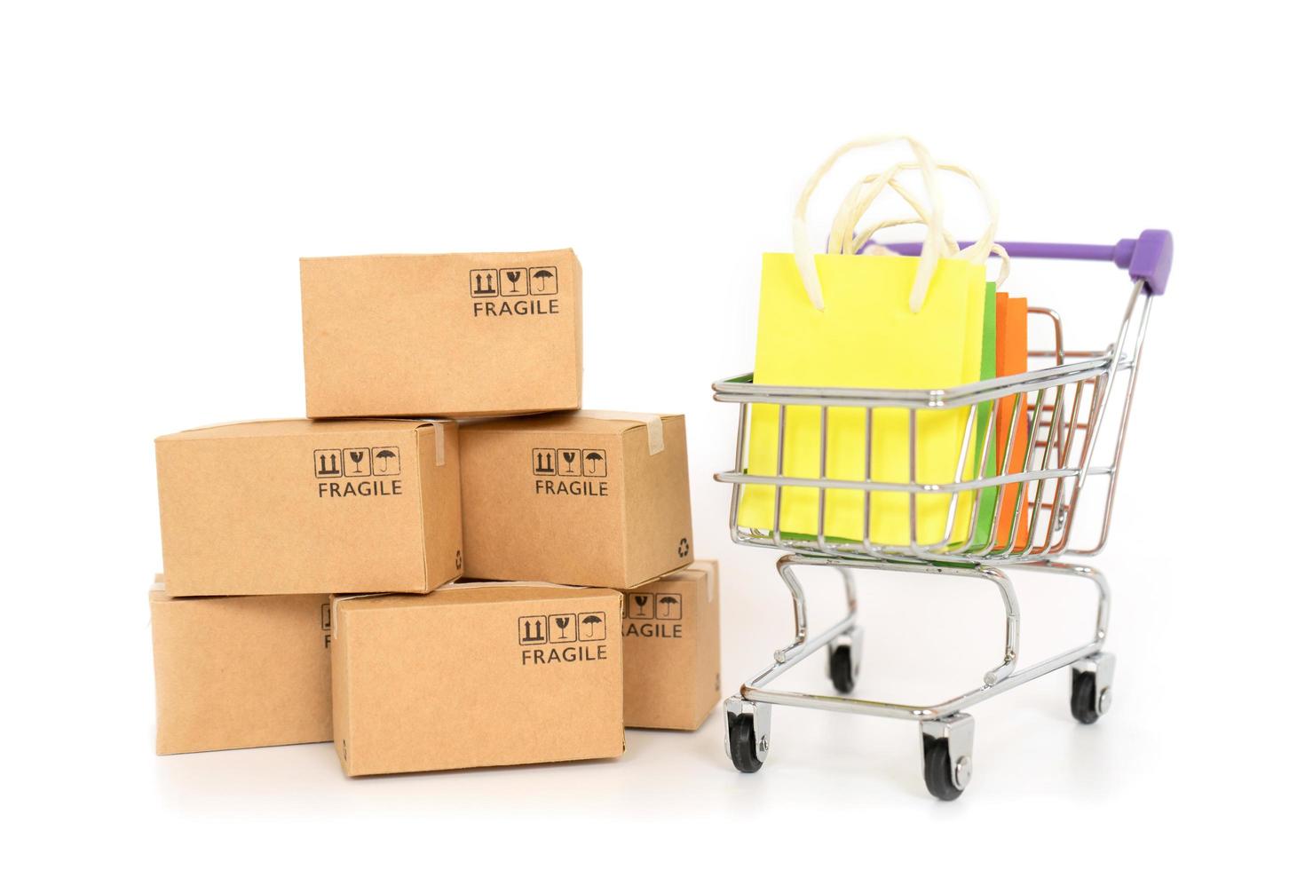 Paper boxes and shopping bags in a trolley on a white background. Online shopping or e-commerce concept and delivery service concept photo