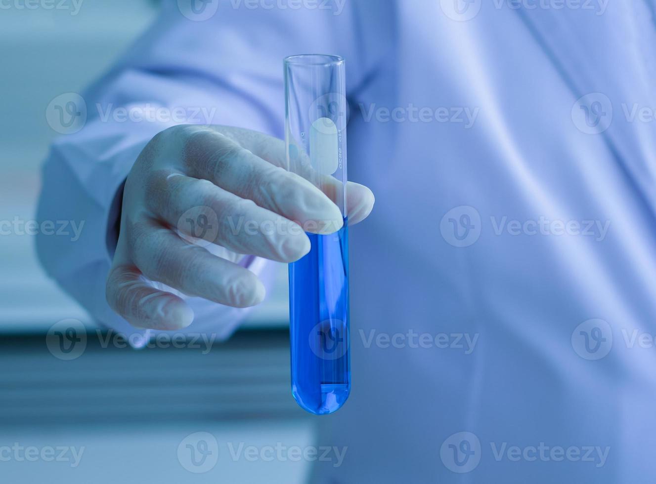 A scientist holding a chemical pipe to a science laboratory photo