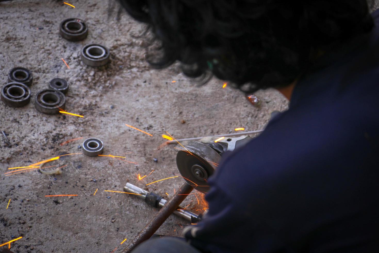 un hombre cortando hierro foto