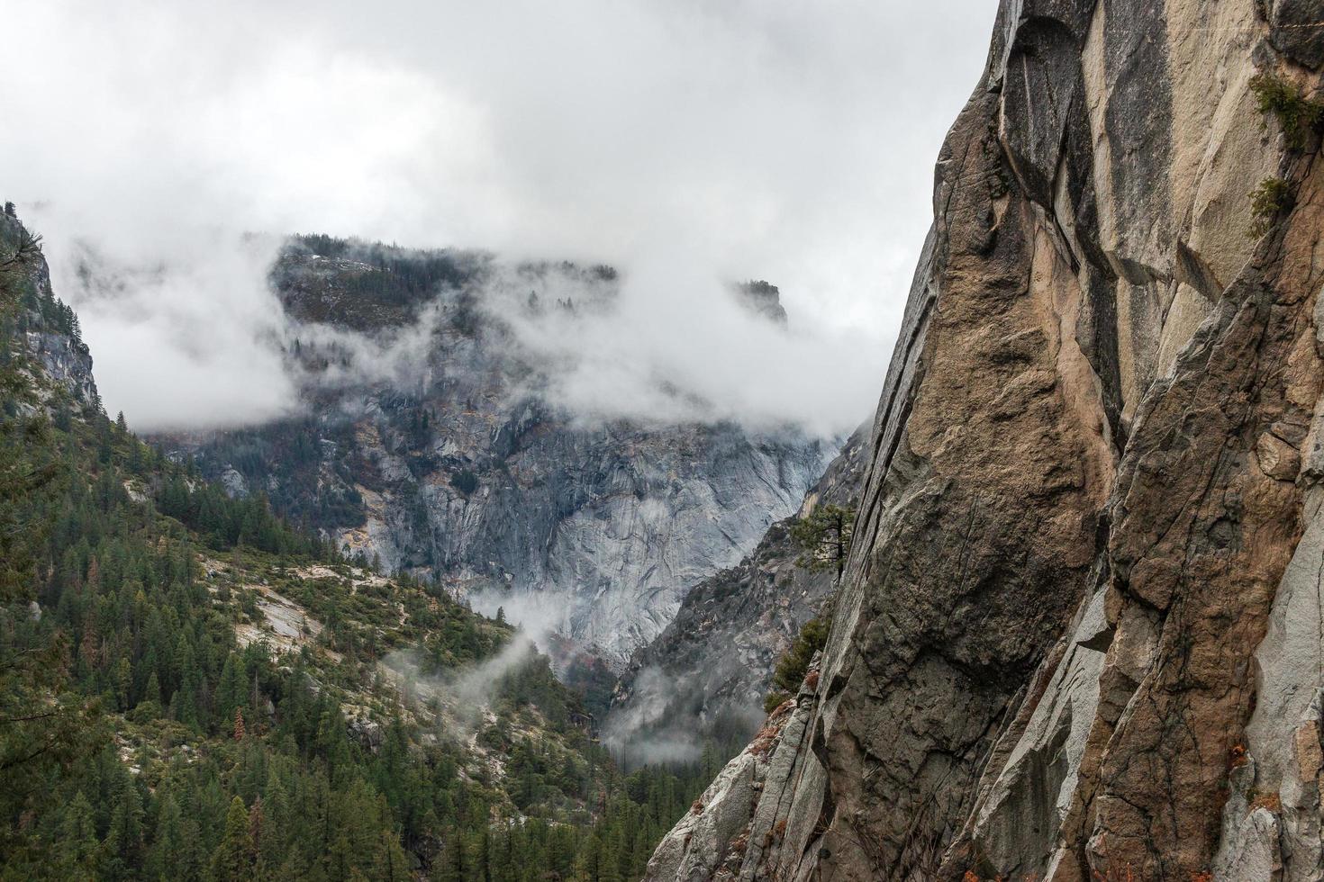 Granite mountain against cloudy winter landscape in Yosemite photo