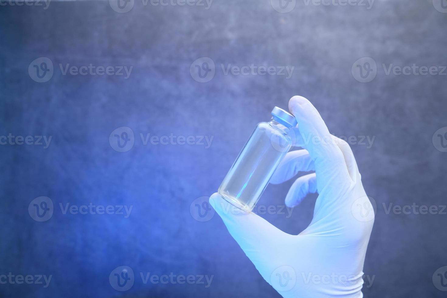Hand in latex gloves holding vaccine with copy space photo