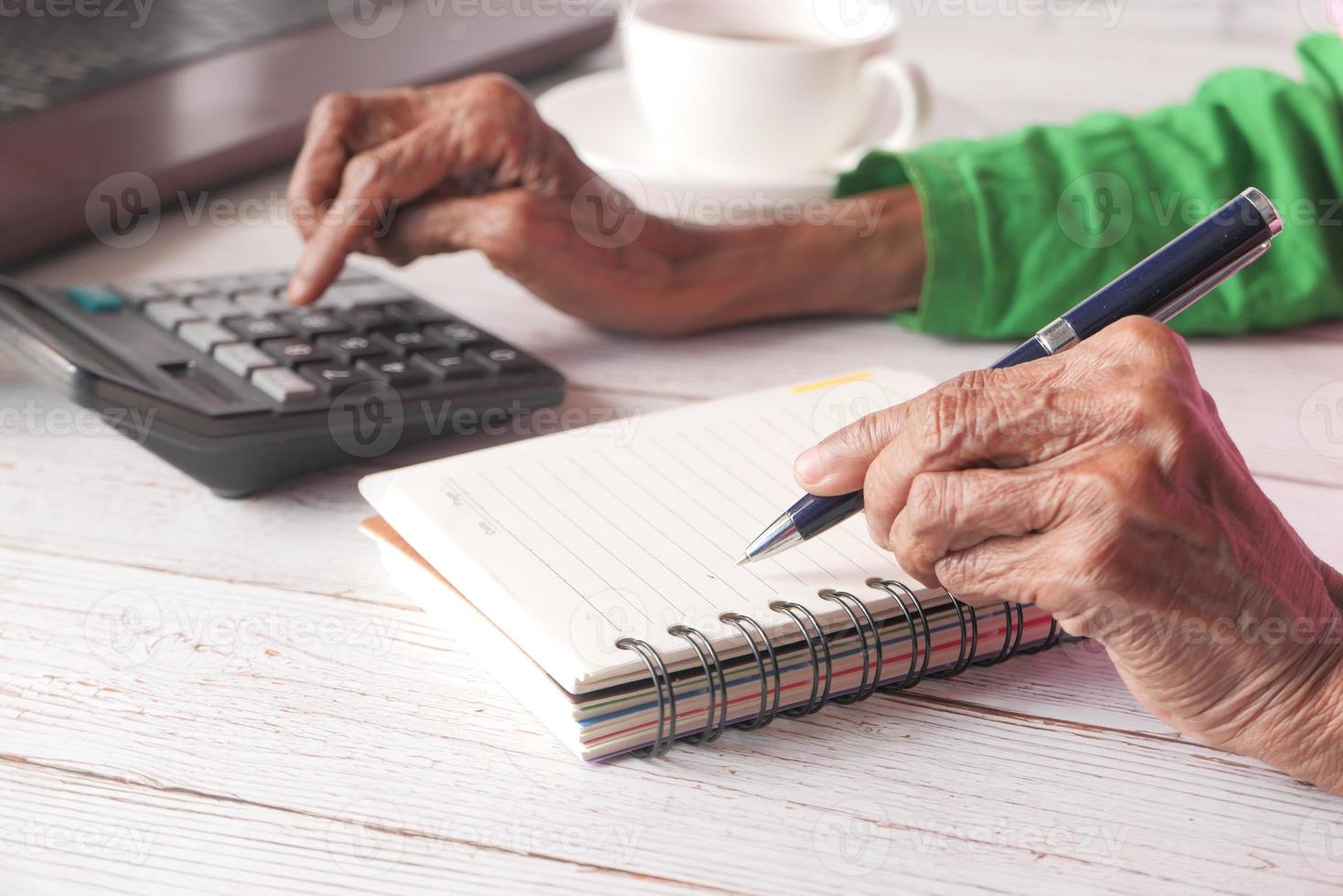 Close up of senior women hand writing on notepad photo