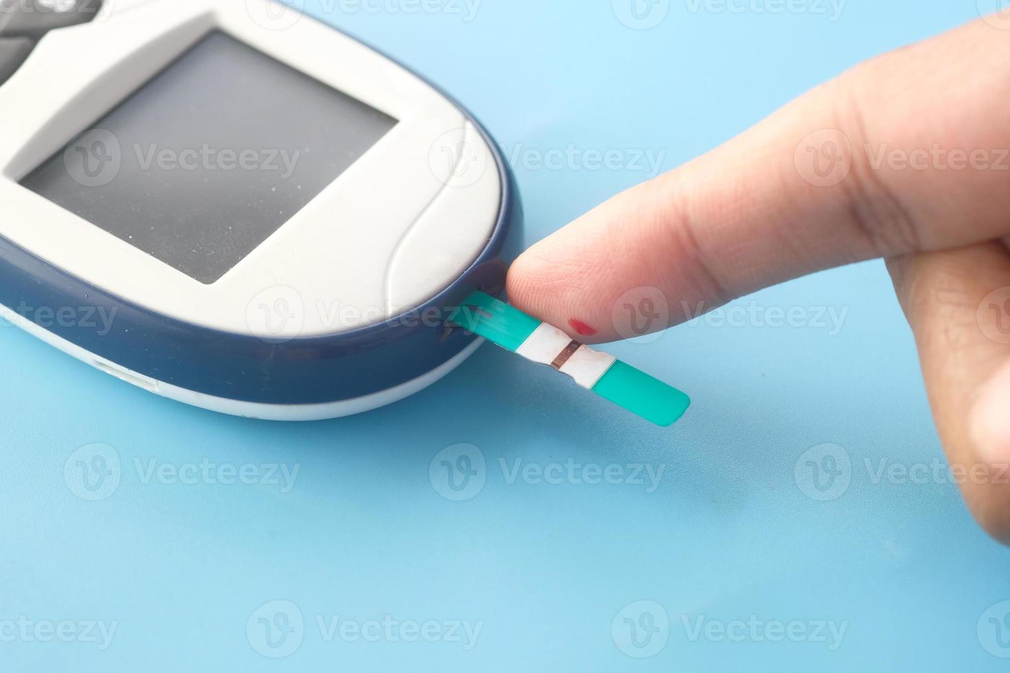 Man's finger measuring glucose level photo