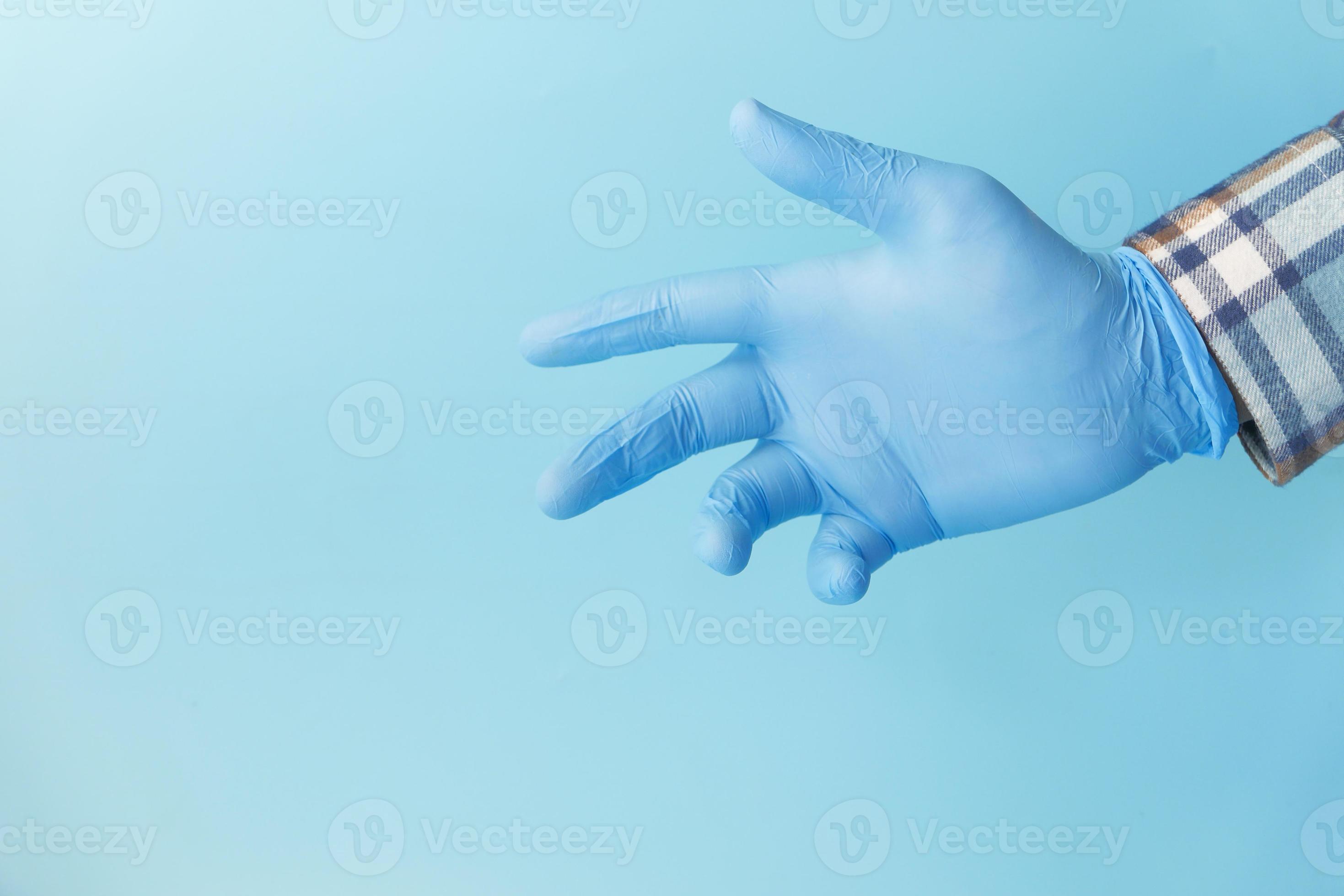 Doctor’s hand with a glove on blue background 2050485 Stock Photo at