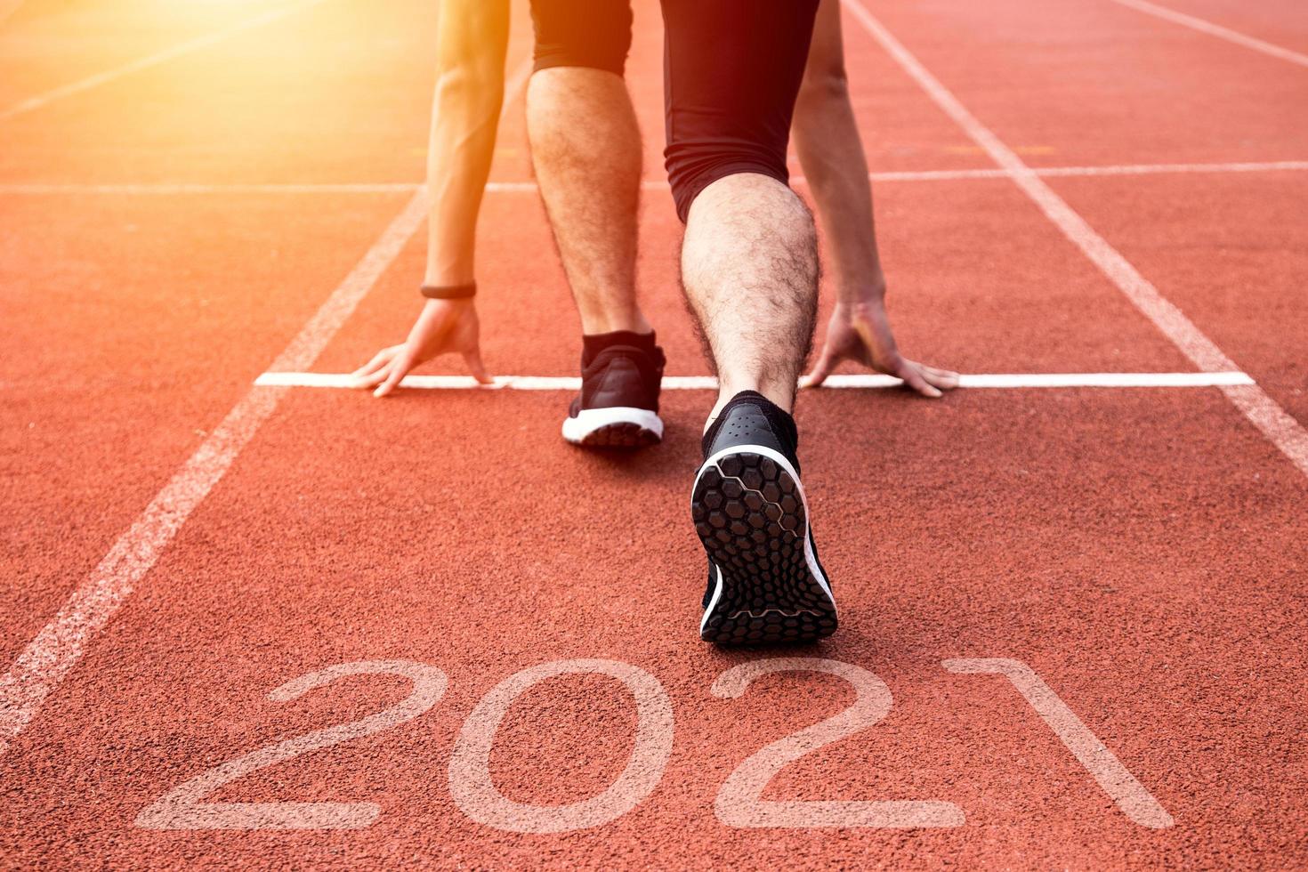 New year or start straight concept. Close up of an athlete runner running to success and new achievements on the path with 2021 inscription photo