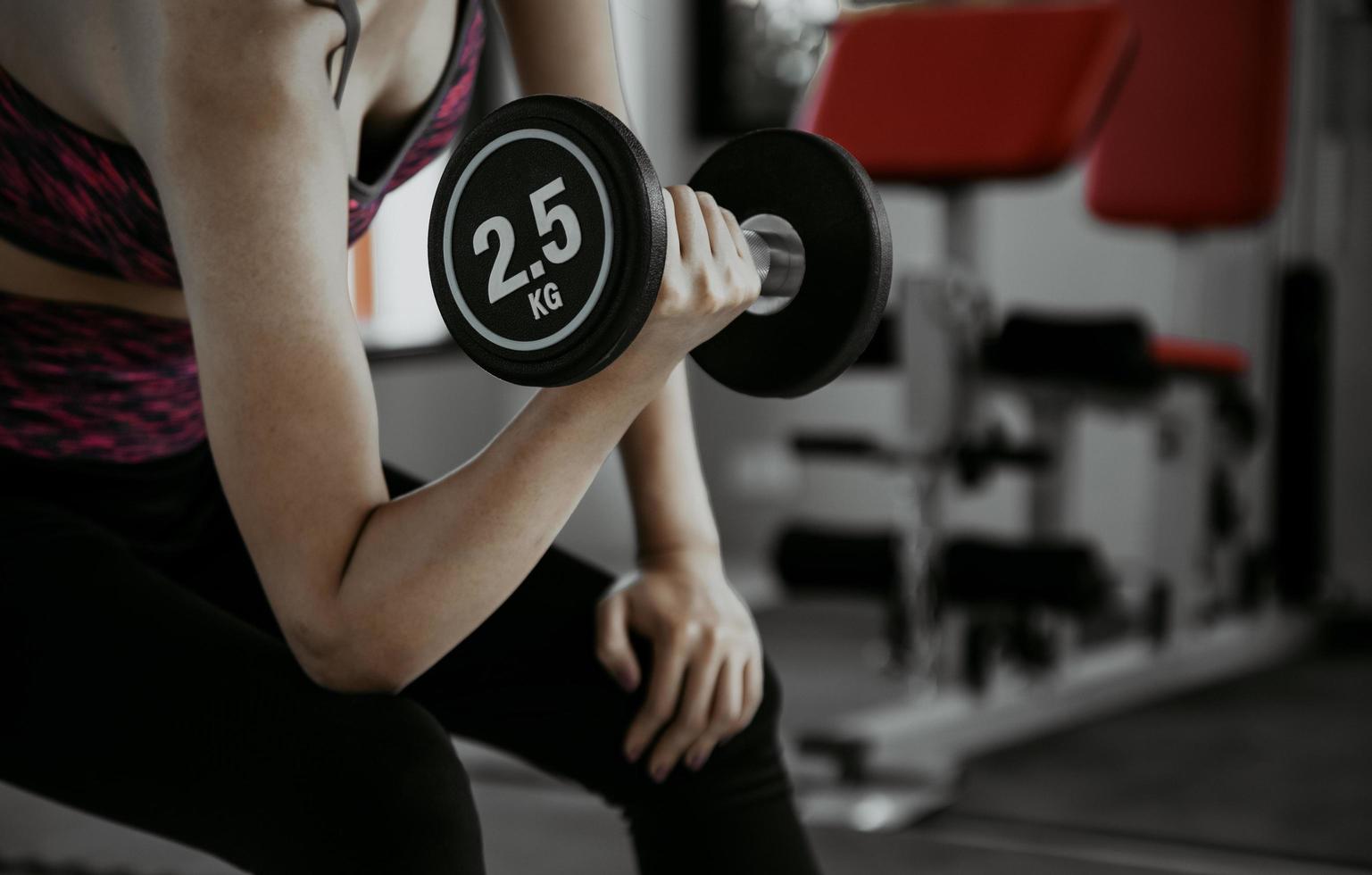 Fitness mujer en entrenamiento con fuertes abdominales mostrando en el gimnasio foto