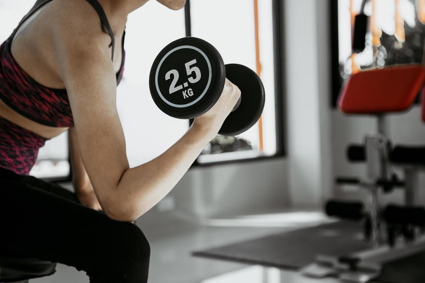 Fitness mujer en entrenamiento con fuertes abdominales mostrando en el gimnasio foto