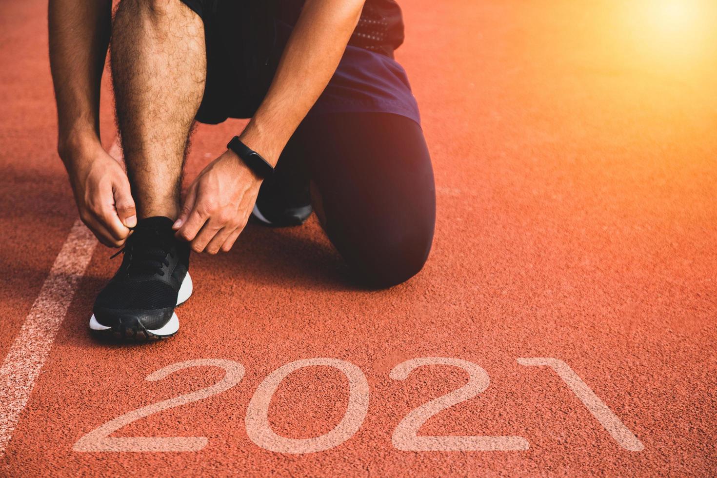 New year or start straight concept. Close up of an athlete runner running to success and new achievements on the path with 2021 inscription photo