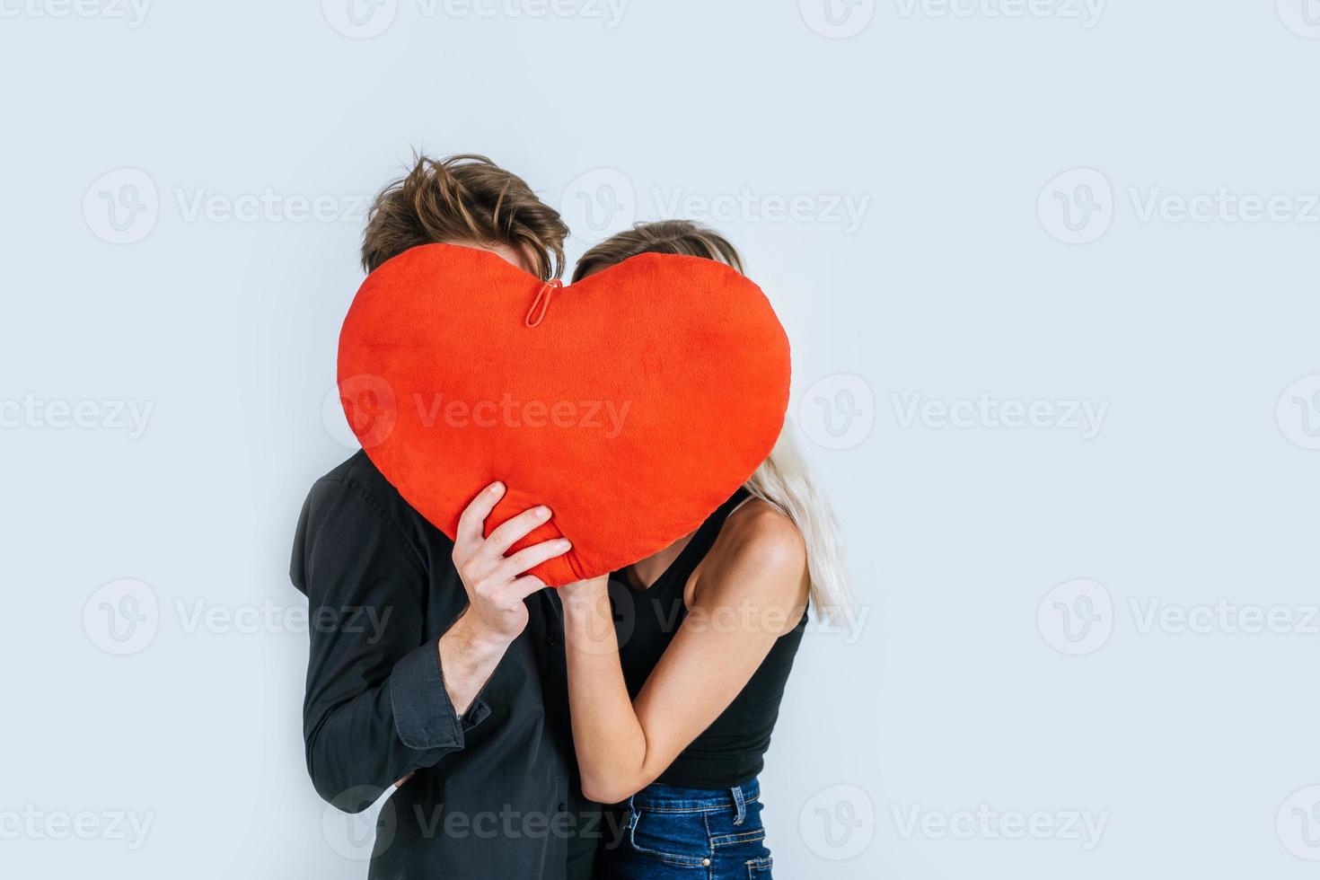 feliz pareja amorosa juntos sosteniendo un corazón rojo foto